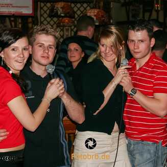 Menschen singen Karaoke in einer Bar.