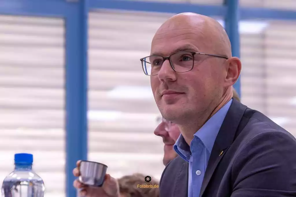 Mann mit Brille und Getränk.