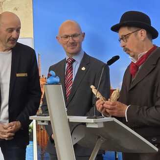 Daniel Keip und André Eckhardt bekamen von Heiko Hesse die ersten Figuren überreicht, die anhand des einzigen bislang bekannten Fotos von Fritze Bollmann entstanden sind. © Stadt Brandenburg an der Havel / Th. Messerschmidt