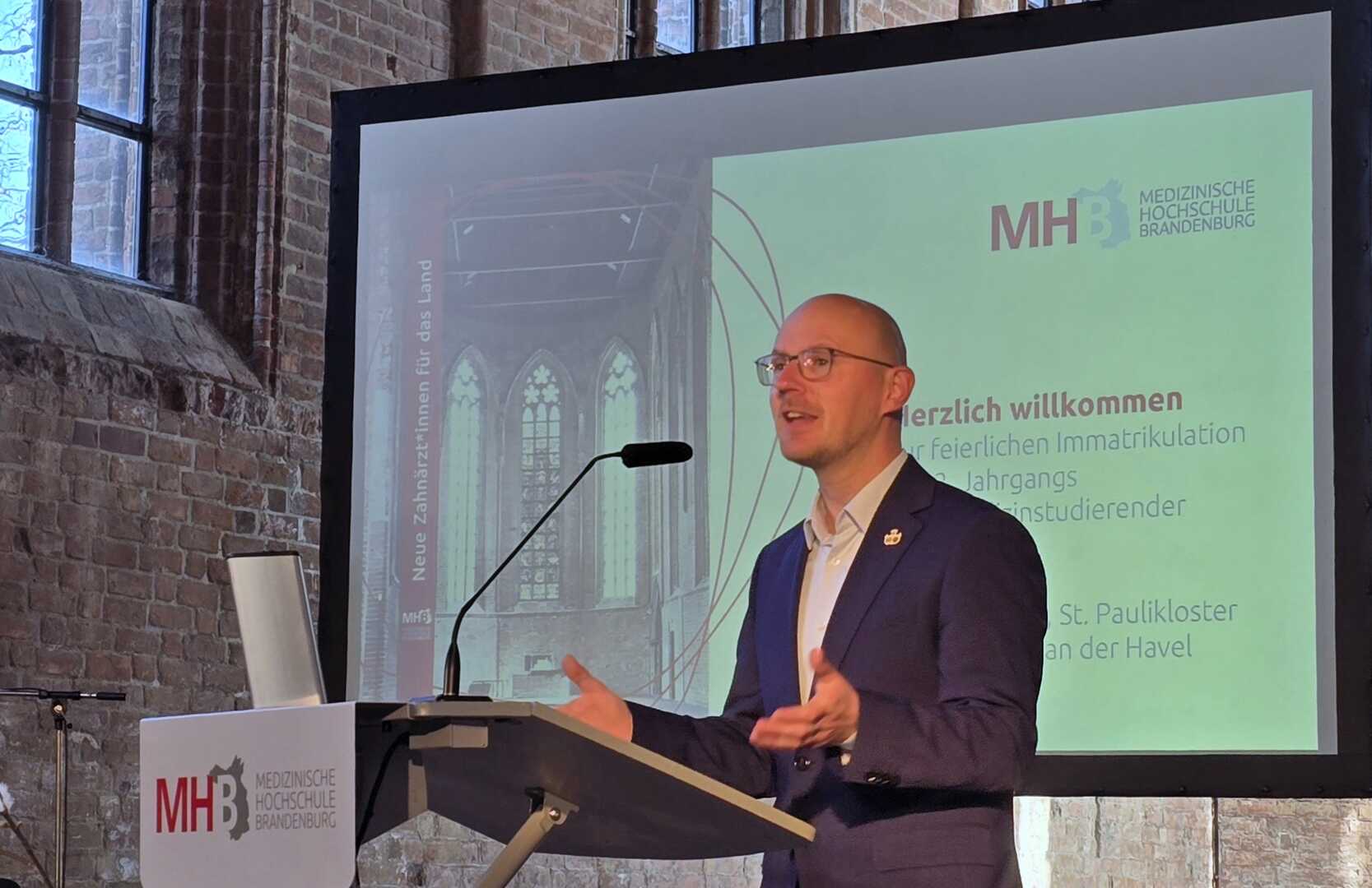 Redner begrüßt neue Zahnmedizinstudenten.