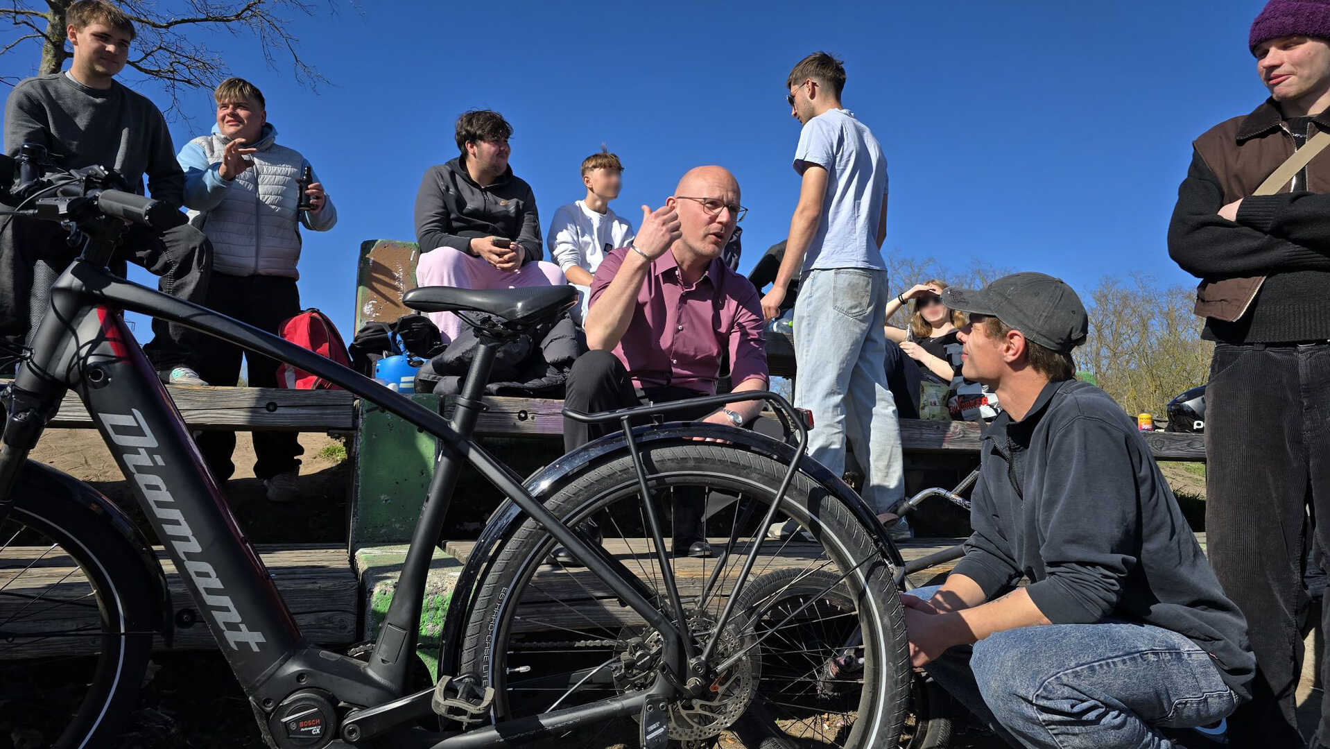 Gruppengespräch im Freien mit Fahrrädern.