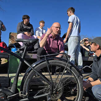 Gruppengespräch im Freien mit Fahrrädern.