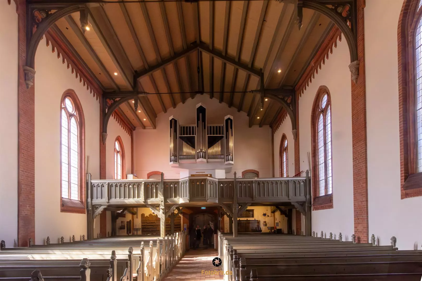 Helle Kirche mit Holzdecke und Orgel.