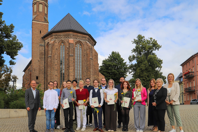 Gruppenbild der Ausbildungs- und Verwaltungsleitung mit den neuen Azubis und Studierenden vor der Johanniskirche. © Stadt Brandenburg an der Havel / René Paul-Peters
