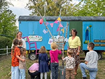 Die Mitarbeiterinnen Sophie Klee (links) und Simone Jacobi (rechts) des Pflegekinderdienstes mit den Kindern vor dem geschmückten Wunschbaum. © Stadt Brandenburg an der Havel / Pflegekinderdienst