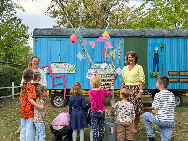 Die Mitarbeiterinnen Sophie Klee (links) und Simone Jacobi (rechts) des Pflegekinderdienstes mit den Kindern vor dem geschmückten Wunschbaum. © Stadt Brandenburg an der Havel / Pflegekinderdienst