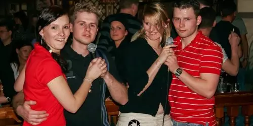 Menschen singen Karaoke in einer Bar.