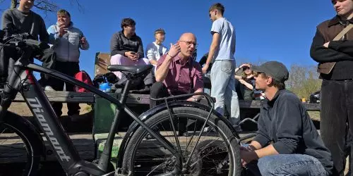 Gruppengespräch im Freien mit Fahrrädern.